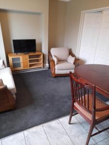 Immingham黑牛旅馆的客厅配有电视、椅子和桌子