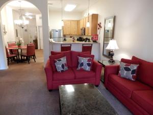 基西米Bahama Bay的一间带两张红色沙发的客厅和一间厨房