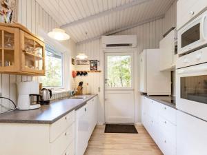 格林哥里8 person holiday home in Roslev的厨房配有白色橱柜和窗户。