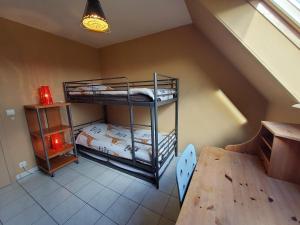 克诺克－海斯特Vakantiehuis in Knokke-Heist met tuin en parkeerplaats的客房设有两张双层床和一张桌子。