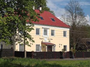 AlbrechticePension Novy Den的一座白色的大建筑,有红色的屋顶