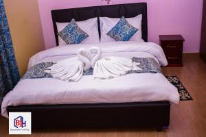 Homa BayBelmont Hotel Homabay的两个白天鹅坐在床上