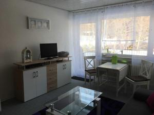 申瓦尔德Ferienwohnung Am Wald的客厅配有电视和带桌子的桌子。