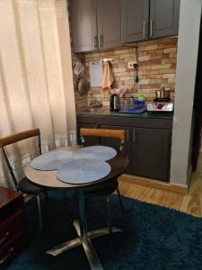 坎帕拉Unia fancy flats - studio apartment two的厨房配有桌子、两把椅子和台面