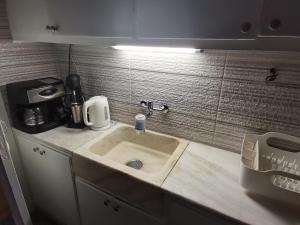 雅典Penthouse spacious w super wifi & terrace, 2 min from metro的厨房水槽上方有灯