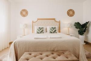 圣塔伦Quinta Monteiro de Matos - Enoturismo的白色卧室配有一张大床和软垫床头板