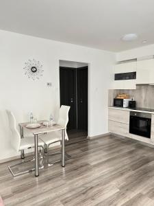 塞格德SunSuite Szeged的一间带桌椅的用餐室和一间厨房