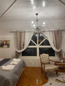 SentaLa Casa Tamaris的一间带吊灯和大窗户的卧室