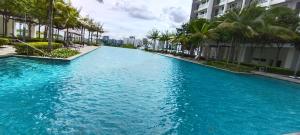 塞贝维Peace home apex的一座拥有建筑和棕榈树的大型蓝色海水游泳池