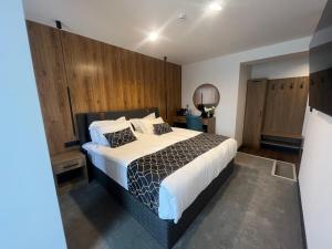 塞夫利耶沃Hotel NIKS的一间卧室配有一张带木墙的大床