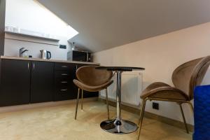 科希策Apart Hotel GOLDEN apartments的一间厨房,内设两把椅子和一张桌子
