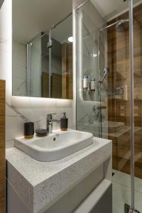 兹拉蒂博尔Golden Pine, a private apartment in five star hotel的一间带水槽和玻璃淋浴的浴室