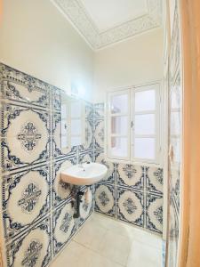 索维拉WELKAM Home & Coworking的浴室拥有蓝色和白色的瓷砖墙壁和水槽