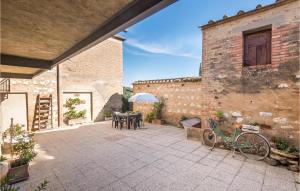 蒙塔尔奇诺Gorgeous Home In Montalcino With Kitchen的一座带桌椅的户外庭院和一座建筑