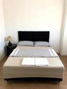 波梅罗迪Apto no centro da cidade mais alemã do Brasil的一张床上有两条白色毛巾的房间