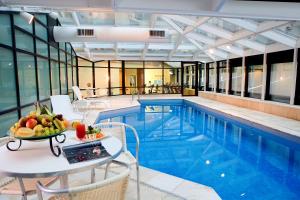 圣保罗Hotel Bourbon Ibirapuera Suite 5 estrelas Moema的一个带桌子的游泳池,上面有一碗水果