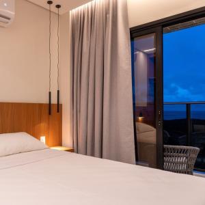 萨利诺波利斯Salinas Premium Resort的一间卧室设有一张床和一个大窗户