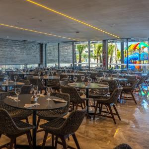 萨利诺波利斯Salinas Premium Resort的一间带桌椅的餐厅和游乐场