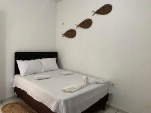 巴雷里尼亚斯Pousada Meu Xodó的卧室配有一张床铺,墙上挂着两个蝴蝶