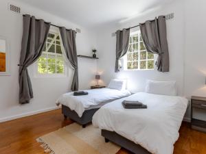 斯泰伦博斯Jonkershoek Valley Cottage的带2扇窗户的客房内的2张床