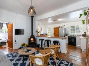 斯泰伦博斯Jonkershoek Valley Cottage的厨房以及带桌椅的起居室。