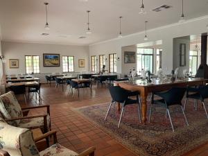 奥奇瓦龙戈Otjibamba Lodge的用餐室设有桌椅和窗户。