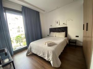 卡萨布兰卡Lovely 1-bedroom rental unit near 2mars/Habous的一间卧室设有一张床和一个大窗户