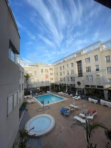 加尔达尔Precioso apartamento en residencial con piscina cerca de la playa的一座大建筑,在庭院里设有一个游泳池