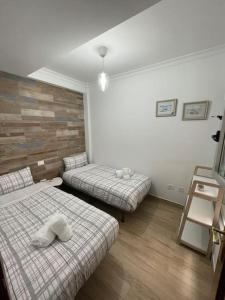 加尔达尔Precioso apartamento en residencial con piscina cerca de la playa的客房设有两张床,铺有木地板。