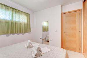 吉亚德伊索拉SELF Check-in Duplex in San Juan with 2 bedrooms的白色卧室,配有白色毛巾