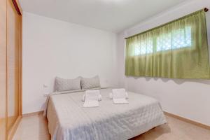 吉亚德伊索拉SELF Check-in Duplex in San Juan with 2 bedrooms的白色卧室配有带两个枕头的床