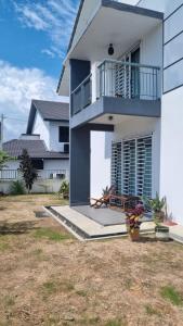 峇株巴辖Baituljannah Homestay Batu Pahat的带阳台和庭院的白色房屋