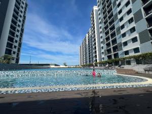 哥打丁宜Desaru Utama Residance Aisy Homestay的两个高楼中间的一个游泳池