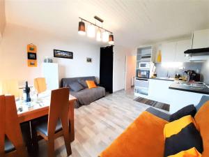 圣拉里苏朗Appartement Saint-Lary-Soulan, 2 pièces, 4 personnes - FR-1-457-308的厨房以及带沙发和桌子的客厅。