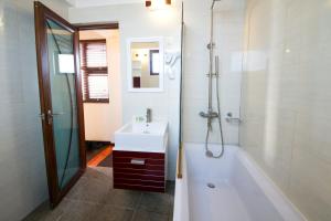 古莉Tropic Tree Maldives的带浴缸、水槽和浴缸的浴室