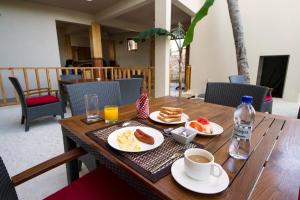 古莉Tropic Tree Maldives的木桌,带盘子的食物和一杯咖啡