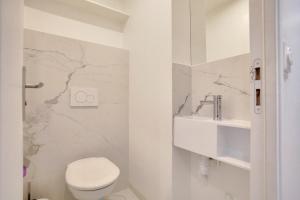巴黎1 Bedroom Louvre Saint Honoré的白色的浴室设有卫生间和水槽。