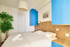 巴黎1 Bedroom Louvre Saint Honoré的卧室配有一张白色大床和蓝色橱柜。