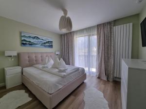 布什泰尼Eminescu Premium Luxury Apartments的一间卧室设有一张床和一个大窗户