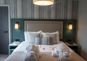 葛特纳格林格雷纳大厅酒店的一间卧室配有一张大床,上面有两双鞋