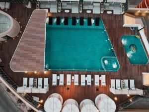 阿尔科兰The House Hotel Al Khiran的享有游泳池的顶部景致,配有一些椅子