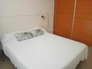 波多黎各Apartamento en Puerto Rico的一张白色的床,上面有枕头