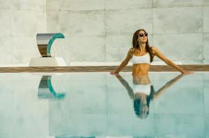 埃斯卡纳安福拉伊维萨酒店的坐在游泳池旁的比基尼的女人