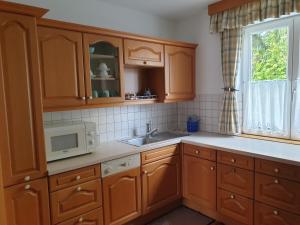 萨尔茨堡Ferienwohnung Claudia的厨房配有木制橱柜、水槽和微波炉