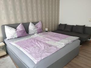 萨尔茨堡Ferienwohnung Claudia的一张配有紫色和白色床单及枕头的大床