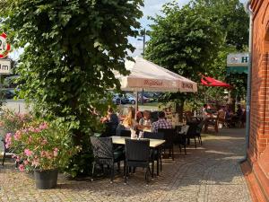 LübzZur Eldenburg的一群坐在户外餐厅的桌子上的人