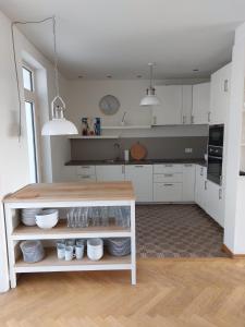 拉纳肯Entre Deux Eaux的厨房配有白色橱柜和餐具柜
