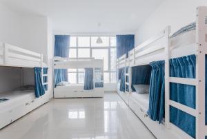 迪拜Skyview Host的带3张双层床和蓝色窗帘的房间