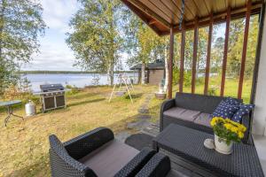 罗瓦涅米Lapland Sunrise Cottage with lakefront Sauna的一个带沙发和烧烤架的门廊