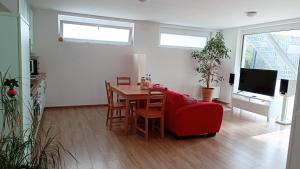 泰克山麓魏尔海姆建筑师公寓的客厅配有桌子和红色椅子